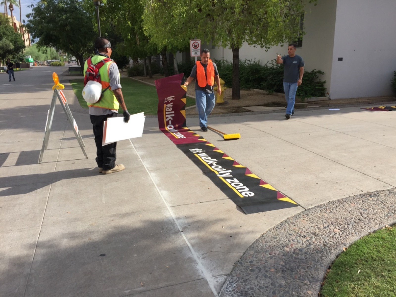 The Sole Images crew installing a walk-only zone decal on campus